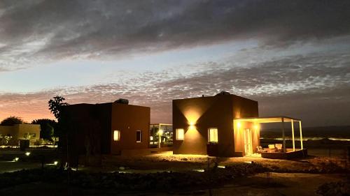a building with the lights on at night at בריזה במדבר in Idan