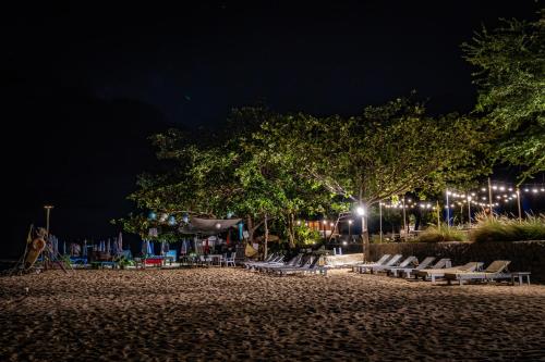 a group of chairs on a beach at night at Boonsong Guest House in Khao Tao