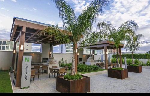 um restaurante com mesas e palmeiras num edifício em Confortável Studio no Park Sul próximo ao aeroporto em Brasília