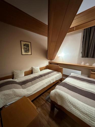 a room with two beds and a window at Apartman 601 i 603 Kopaonik Centar in Kopaonik