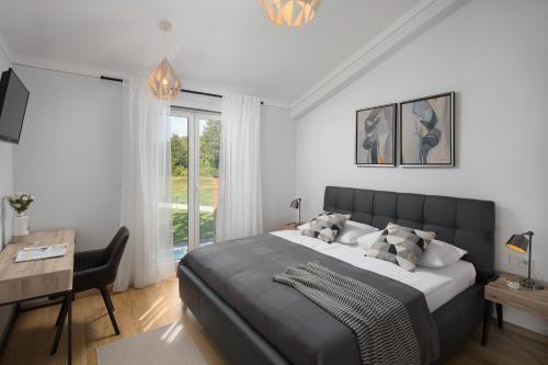 een slaapkamer met een groot bed, een bureau en een tafel bij Villa Analucija 2 in Polje Čepić