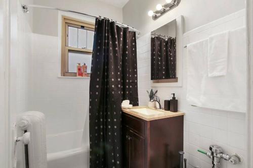 Łazienka wyposażona jest w czarną zasłonę prysznicową i umywalkę. w obiekcie Chic & Contemporary Studio Apartment - Bstone 120 w Chicago