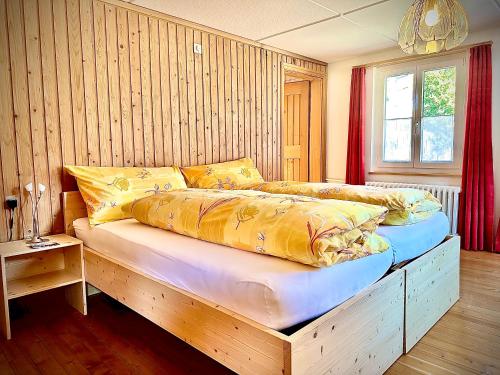 a bedroom with a large bed with yellow pillows at Gasthof Ochsen in Nesslau