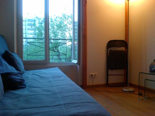 une chambre avec un lit et une grande fenêtre dans l'établissement calme et repos, vue sur les arbres, à Paris