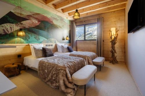 a bedroom with two beds and a painting on the wall at Chalet Le Bouquetin in Saint-François-Longchamp