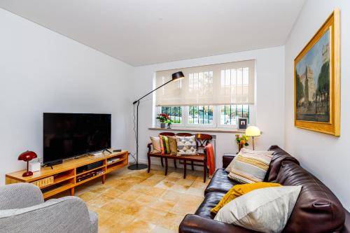 a living room with a couch and a flat screen tv at Augusto - your family house in the heart of Lisbon in Lisbon