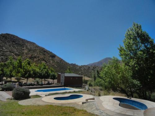 two swimming pools in a yard with mountains in the background at Viví Potrerillos in Potrerillos