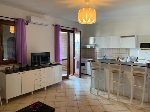 una cocina con armarios blancos y una gran isla en Appartamento Eurogarden, en San Foca