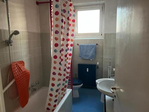 een badkamer met een douchegordijn, een toilet en een wastafel bij CASABELLA in Monza