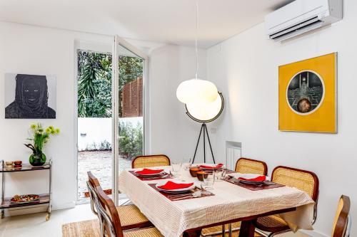 Augusto - your family house in the heart of Lisbon في لشبونة: غرفة طعام بيضاء مع طاولة وكراسي