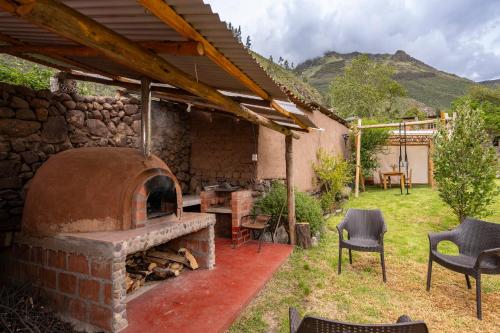 an outdoor oven with a table and chairs in a yard at Unuwasi Hotel & Villa in Calca