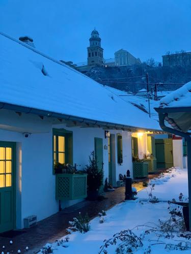 a house with snow on the roof at night at Pannonhalma Várlak Vendégház in Pannonhalma