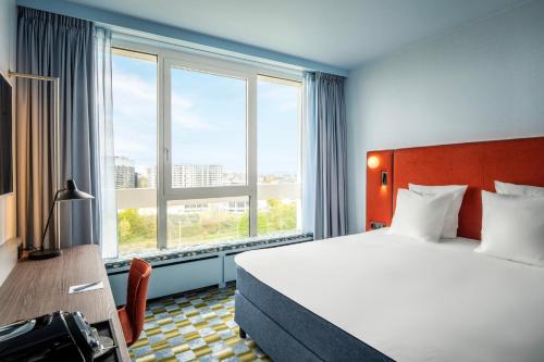 a hotel room with a bed and a large window at Crowne Plaza Antwerpen, an IHG Hotel in Antwerp