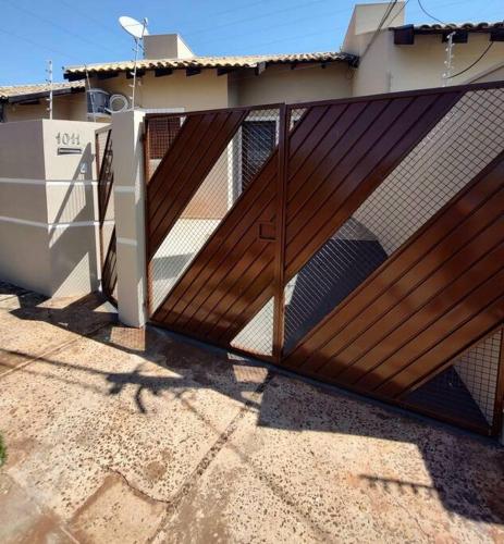 una puerta de madera frente a una casa en Casa privativa próximo ao centro e aeroporto. en Campo Grande