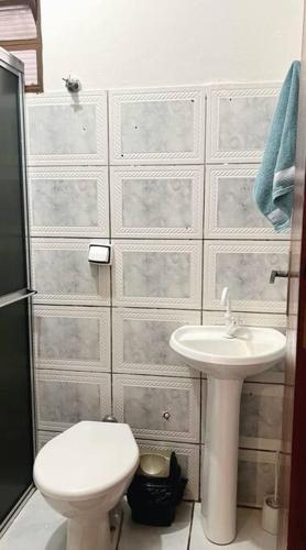 a bathroom with a toilet and a sink at Casa privativa próximo ao centro e aeroporto. in Campo Grande