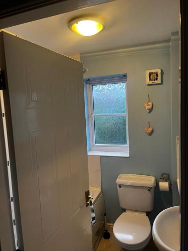 ein Badezimmer mit einer weißen Toilette und einem Waschbecken in der Unterkunft Brades Rise House - 3 bedroom house with 2 toilets with a private garden in Birmingham