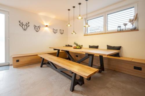 a dining room with a table and benches at Residence Smržovka - Luxury House with Swimming Pool, Jacuzzi, Garden and BBQ in Jablonec nad Nisou