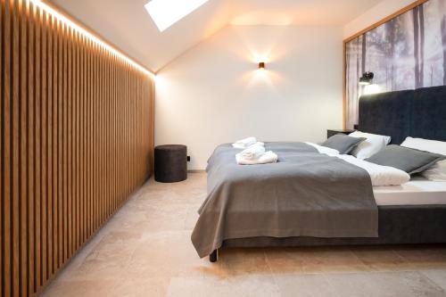 a bedroom with a bed and a large wooden wall at Residence Smržovka - Luxury House with Swimming Pool, Jacuzzi, Garden and BBQ in Jablonec nad Nisou
