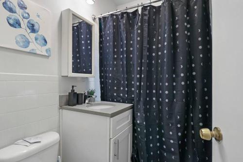 a bathroom with a shower curtain with a toilet and a sink at Modern Chic 1BR in Downtown Chicago - Dorchester 204 in Chicago