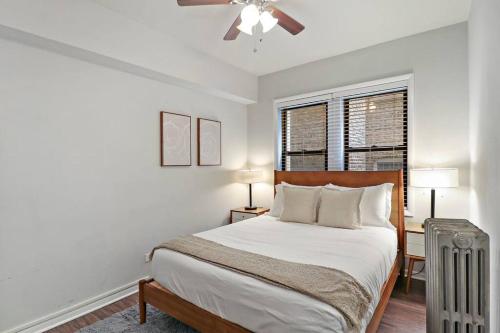 a white bedroom with a bed and a fan at Modern Chic 1BR in Downtown Chicago - Dorchester 204 in Chicago