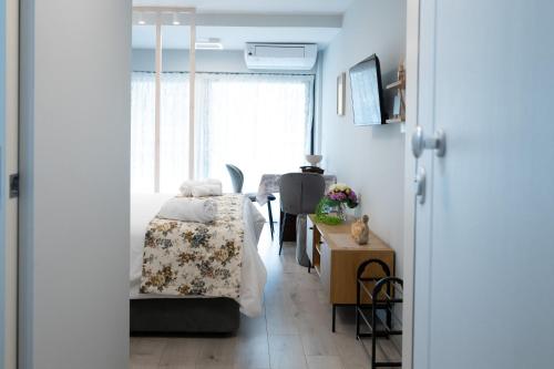 a bedroom with a bed and a table and a window at La Luna Lux Studio in Ioannina