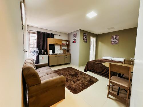 a living room with a couch and a bed at Apartamento ótima localização in Passo Fundo