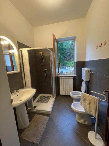a bathroom with two toilets and a sink and a shower at Casa in campagna: Completo Relax in Albissola Marina