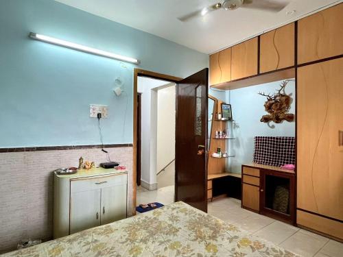 a kitchen with blue walls and wooden cabinets at Calm Private Room with Beautiful View in Mumbai