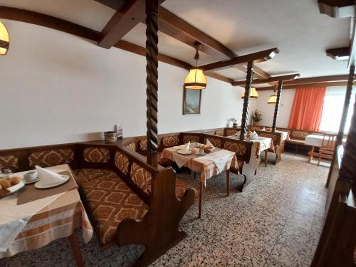 ein Restaurant mit Sofas und Tischen in einem Zimmer in der Unterkunft Pension Stausee in Sankt Jakob im Rosental