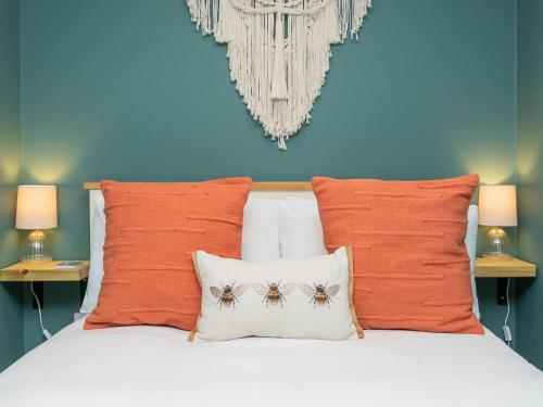 1 dormitorio con 1 cama con almohadas de color naranja en Pass the Keys 2 bed flat in fabulous location with parking en Bath