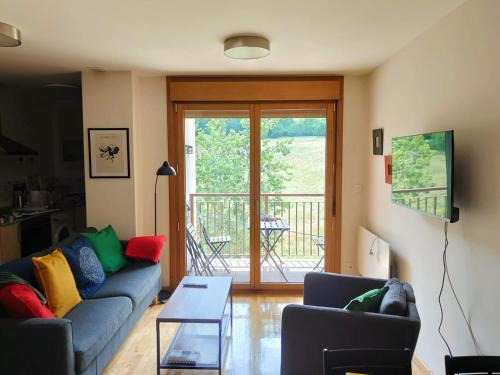 a living room with a couch and a table at Ventana al Paraíso del Oso - Somiedo. Window to Bear Paradise - Somiedo in Pola de Somiedo