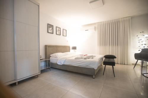 a bedroom with a bed and a chair in it at Sweet Dreams Apartment in Tiberias