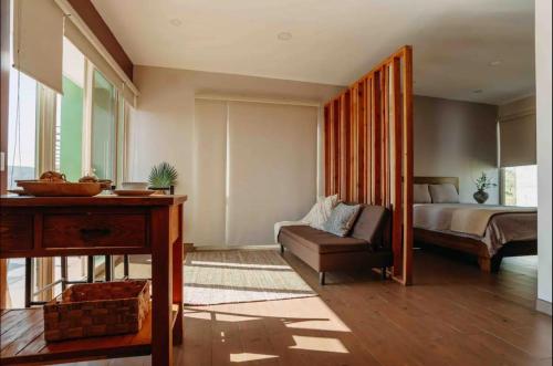a bedroom with a bed and a couch and a table at Casa Berty 1 in Ensenada