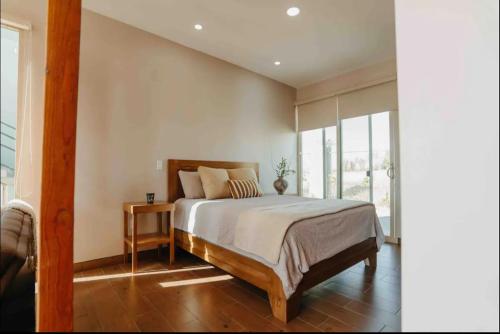 een slaapkamer met een bed en een groot raam bij Casa Berty 1 in Ensenada