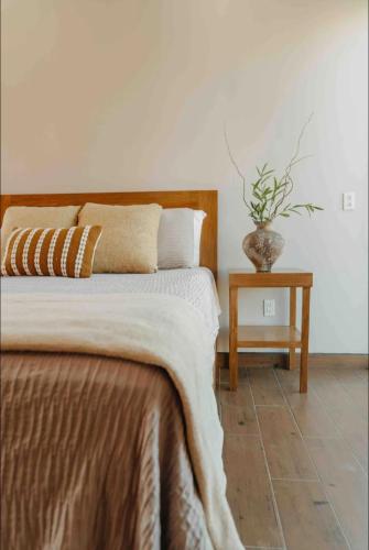 a bedroom with a bed and a table with a plant at Casa Berty 1 in Ensenada