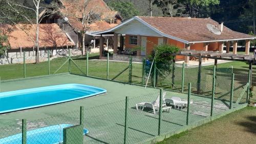 een hek rond een zwembad voor een huis bij Chácara São José in Piranguçu