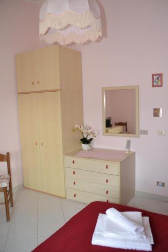 a bedroom with a dresser and a mirror at Vicky's B&B by V in Papasidero