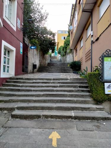 a set of stairs in an alley between buildings at Albergue HR in Sarria