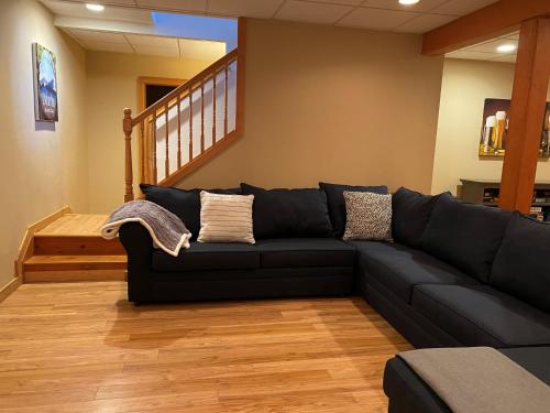 a black couch in a living room with a staircase at Gorgeous House in Camelback Mountain near lifts! in Tannersville