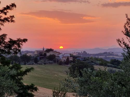 un tramonto su una piccola città su una collina di Camping San Procolo a Monte Vidon Combatte