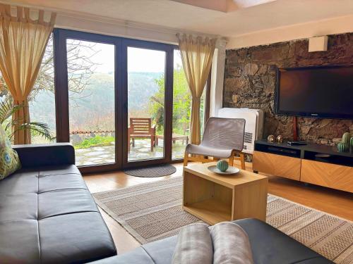 a living room with a couch and a tv at Retiro de Gondramaz - Entire 200 m2 in Gondramaz