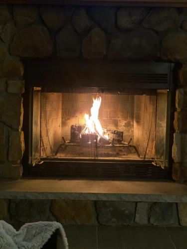 a brick fireplace with a fire in it at Gorgeous House in Camelback Mountain near lifts! in Tannersville