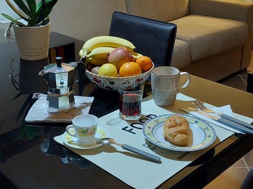 einen Tisch mit einer Schale Obst und einer Schüssel Brot in der Unterkunft Relax & Business Luxury Apartment Velletri in Velletri
