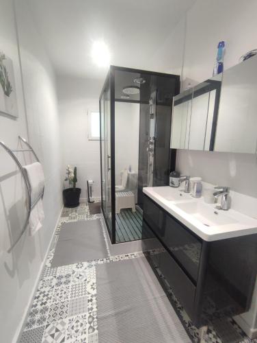 La salle de bains est pourvue d'une douche, de 2 lavabos et d'un miroir. dans l'établissement Charmante maison près du Futuroscope, à Saint-Georges-lès-Baillargeaux