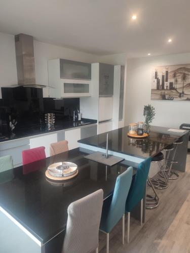 une salle à manger avec une table et des chaises noires dans l'établissement Charmante maison près du Futuroscope, à Saint-Georges-lès-Baillargeaux