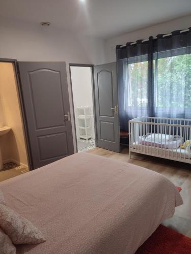- une chambre avec un lit et un lit bébé dans l'établissement Charmante maison près du Futuroscope, à Saint-Georges-lès-Baillargeaux