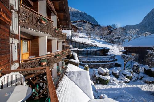 a snow covered balcony of a house with snow on the ground at Hôtel Les Côtes, Résidence Loisirs et Chalets in Morzine