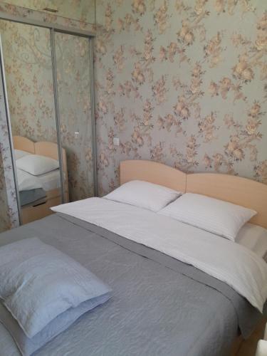 a bedroom with a large bed with a mirror at Cathedral Park Medium Apartment in Chişinău