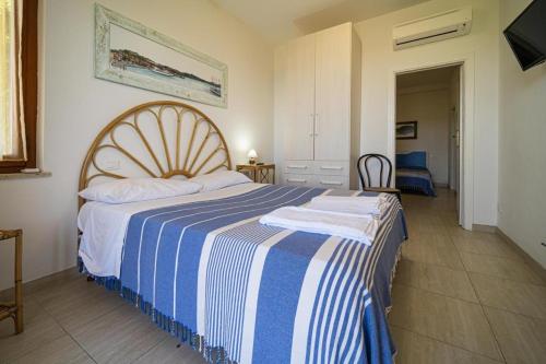 a bedroom with a bed with a blue and white striped blanket at Villa Ray in Capoliveri
