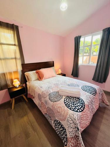 a bedroom with a bed and two windows at La Casita in Pátzcuaro